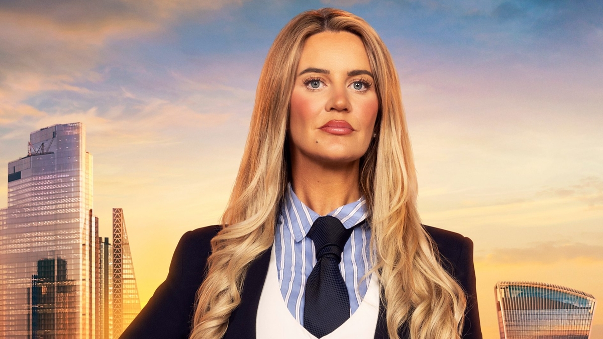 Aoibheann Walsh looks into the camera in front of the London skyline, wearing a black blazer and tie, white waistcoat and striped blue shirt