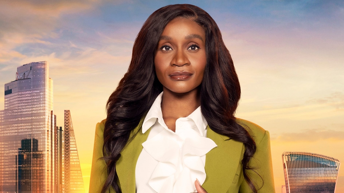 Chisola Chitambala looks into the camera in front of the London skyline, wearing a green blazer and white shirt with a frilled piece