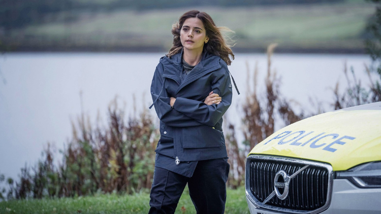 Jenna Coleman as Ember walks away from a police car, arms folded and looking concerned