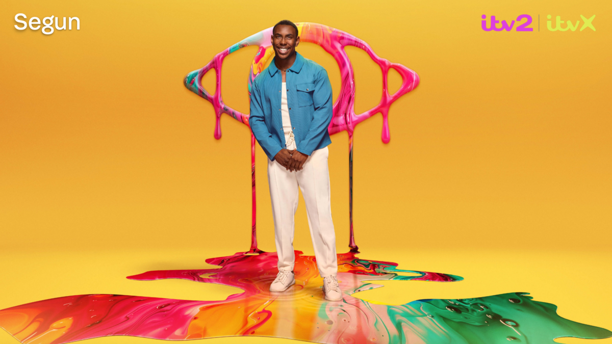 Segun poses in front of a yellow backdrop and the Big Brother logo