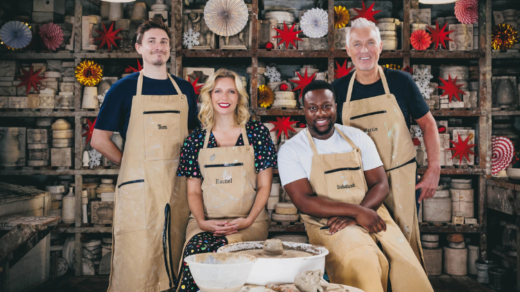 om Rosenthal, Rachel Riley, Babatunde Aleshe and Martin Kemp stand in a pottery studio, wearing beige aprons and smiling