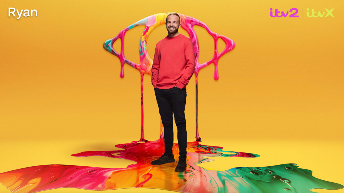 Ryan poses in front of a yellow backdrop and the Big Brother logo