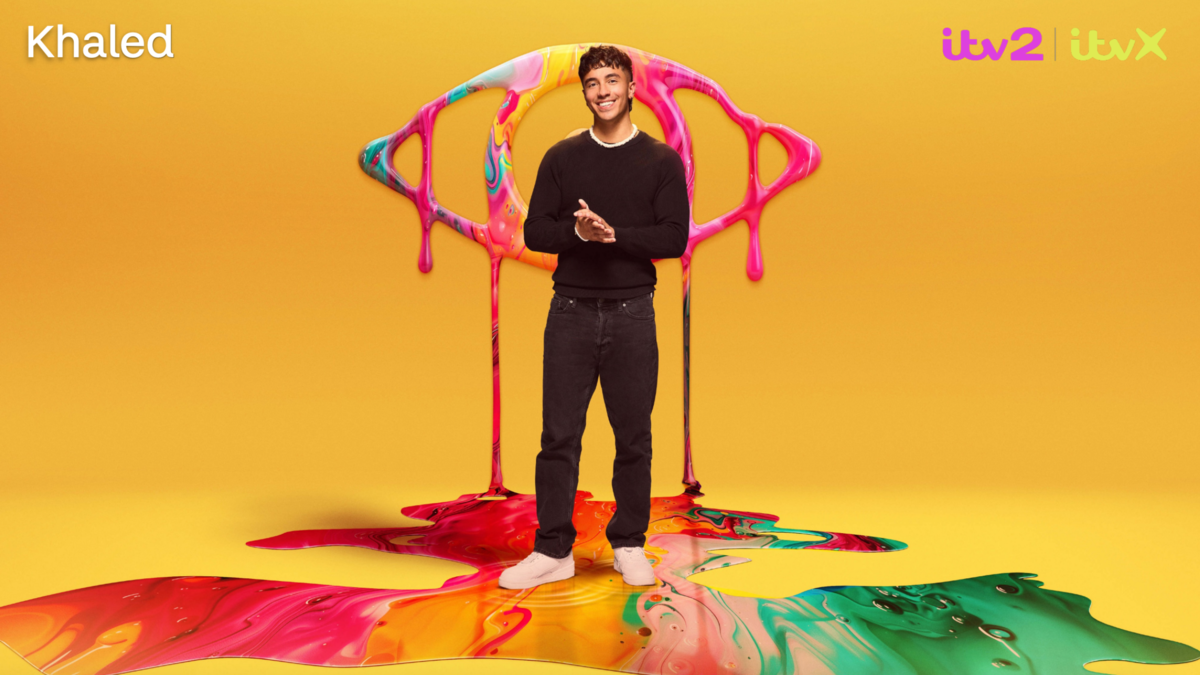 Khaled poses in front of a yellow backdrop and the Big Brother logo