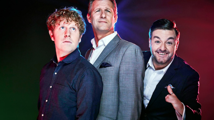 Josh Widdicombe, Adam Hills and Alex Brooker pose in front of a black backdrop, Widdicome and Hills looking serious and into the distance, Brooker looking into the camera and grinning