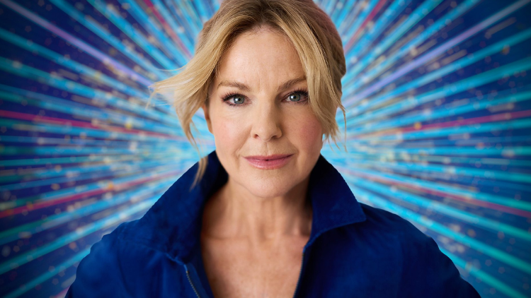 Sarah Hadland smiles in front of a glittery blue backdrop