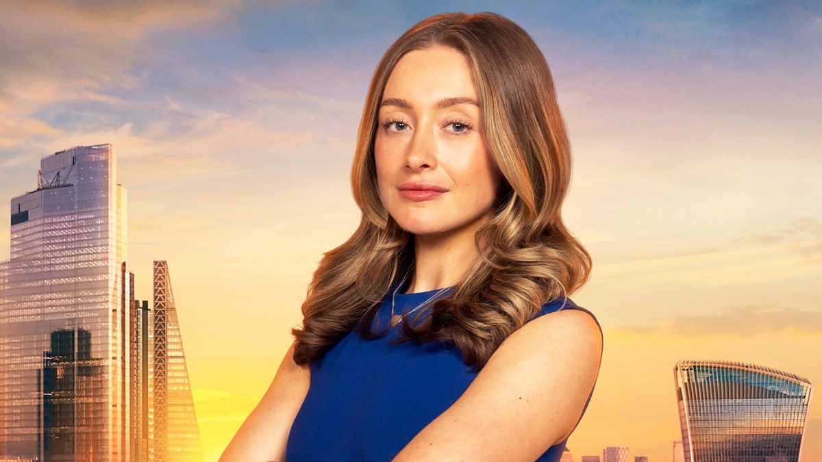 Mia Collins looks into the camera in front of the London skyline, wearing a blue business-attire dress