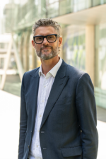 A photo of Diederick Santer, smiling in a suit