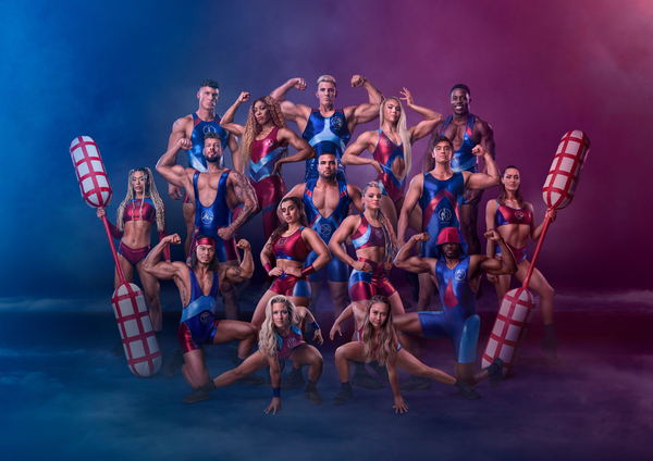 The vast ensemble of Gladiators flex for the camera against a cloudy blue/purple backdrop