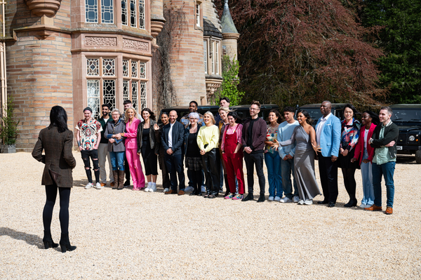 The 22 contestants of The Traitors stand outside the castle awaiting Claudia Winkleman's instructions