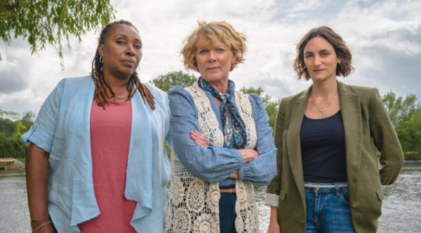 Jo Martin, Samantha Bond and Cara Horgan stand outdoors, looking into the camera with suspicious looks on their faces