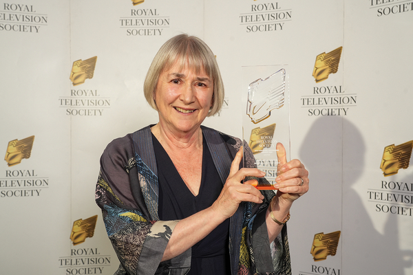 Gwyneth Hughes stands holding her RTS Yorkshire award trophy