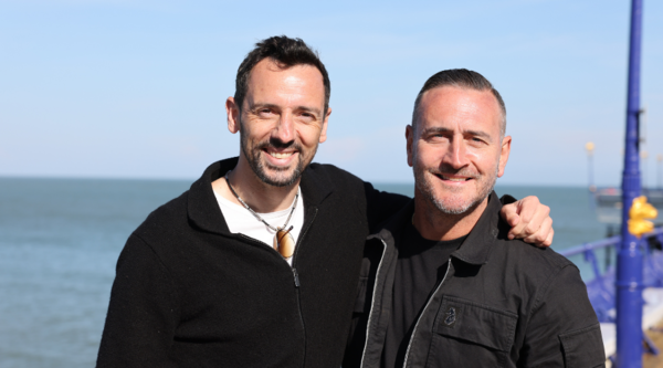 Ralf Little and Will Mellor stand arm-in-arm in front of the sea