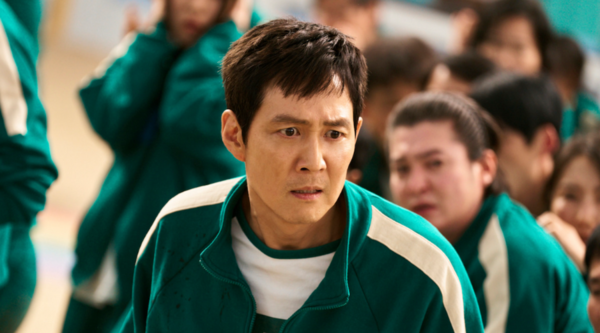 Lee Jung-jae looks distressed in a green Squid Game tracksuit