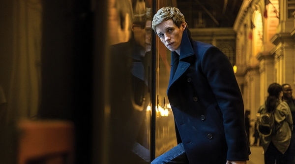 Eddie Redmayne steps onto a train as the titular assassin of The Day of the Jackal