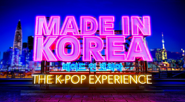The words "Made In Korea" are written in a graphic of a pink neon sign, above "The K-Pop Experience" in yellow neon. Between the two, there is Korean writing in blue neon signage