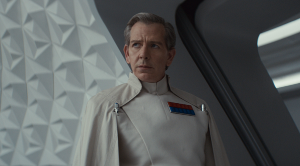 Ben Mendelsohn, a white man in his fifties, wears a white Imperial uniform against a white interior