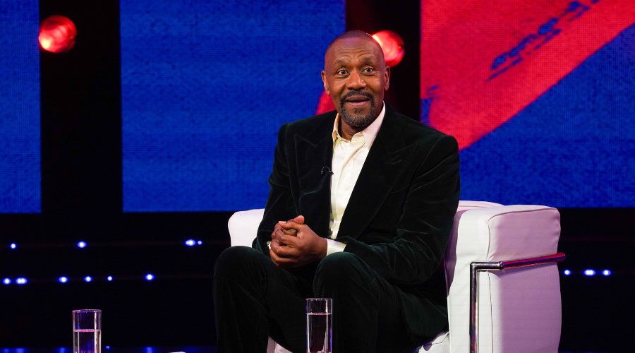 Lenny Henry sits down in a TV studio, looking off camera