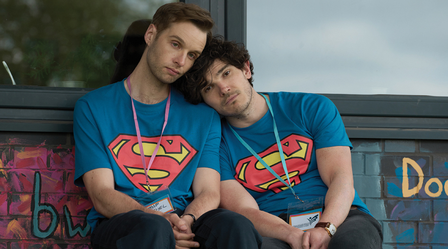 The two central boys in Lost Boys & Fairies sit side by side, leaning on one another, and both wearing the same Superman T-shirt