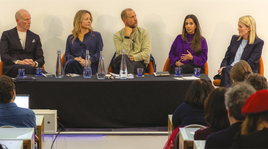 Two men and three women sit in a row on a panel discussion