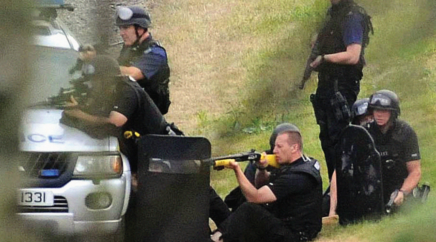 A group of seven policemen aim their weapons