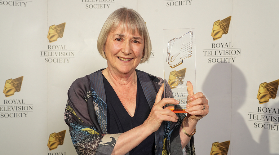 Gwyneth Hughes stands holding her RTS Yorkshire award trophy