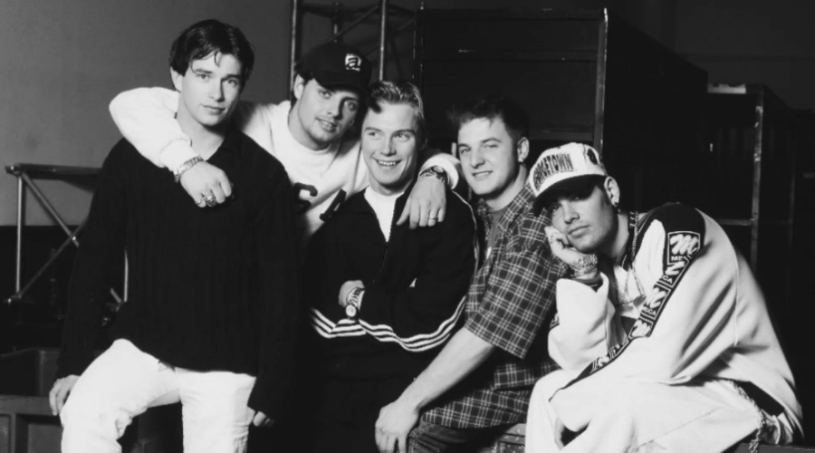 Stephen Gately, Keith Duffy, Ronan Keating, Michael Graham, Shane Lynch pose in a black and white photo from the 1990s