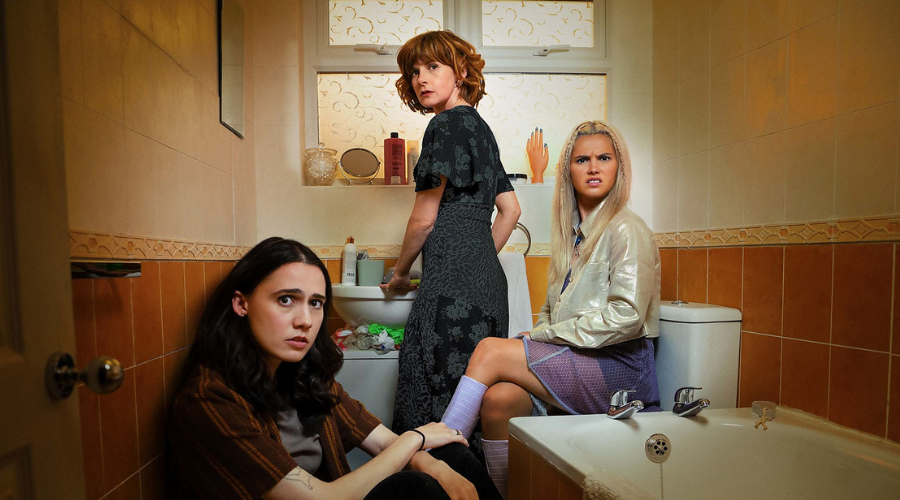 Kat Sadler, Louise Brealey and Lizzie Davidson in their bathroom, looking into the camera with confusion and, in Lizzie's case, disgust