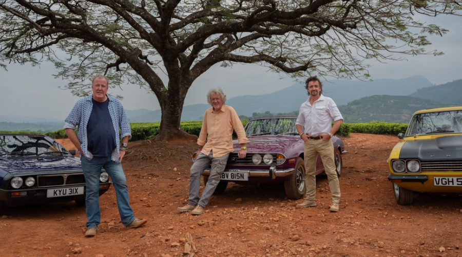 Jeremy Clarkson, James May and Richard Hammond stand in front of three cars in Zimbabwe