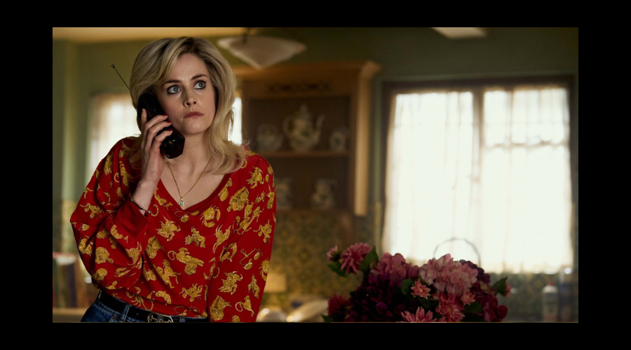 Stefanie Martini, a white woman in her thirties, is on the phone, wearing a red top