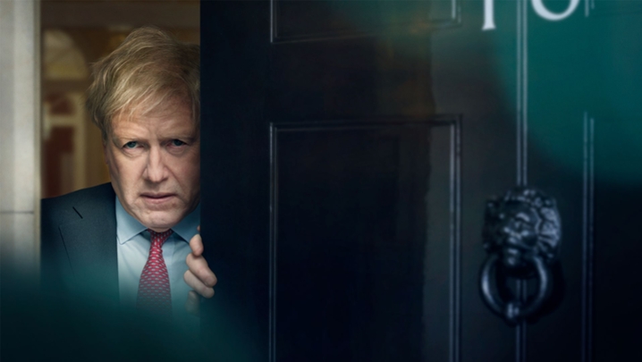 Actor Kenneth Branagh playing blonde-haired Prime Minister Boris Johnson opening door of Number 10 Downing Street