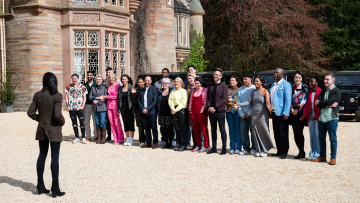 The 22 contestants of The Traitors stand outside the castle awaiting Claudia Winkleman's instructions