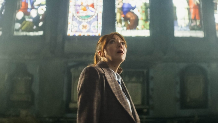 Diane Morgan as Philomena Cunk stands in a church while gazing upwards