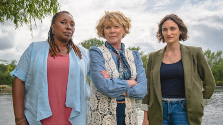 Jo Martin, Samantha Bond and Cara Horgan stand outdoors, looking into the camera with suspicious looks on their faces