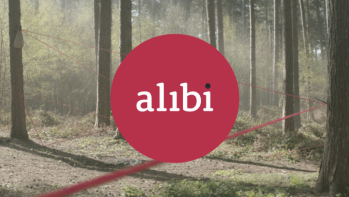 The Alibi logo superimposed in front of a forest