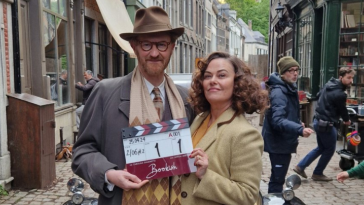 Mark Gatiss and Polly Walker in 1940s dress, holding a clapperboard for slate one take oneBookish