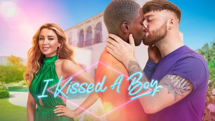 two contestants kiss in front of Dannii Minogue with the lettering "i kissed a boy" overlaid