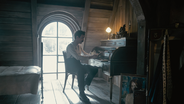 Ewan McGregor plays Alexander Rostov, sitting at a writing desk in an attic