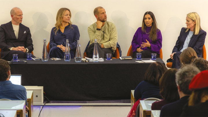 Two men and three women sit in a row on a panel discussion