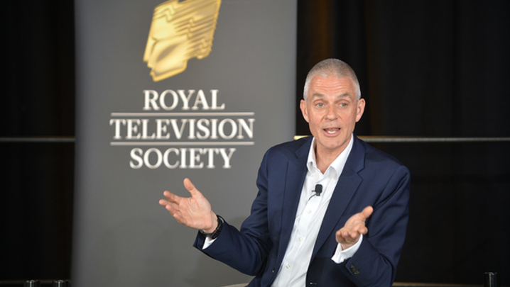 Tim Davie sits in front of a Royal Television Society banner
