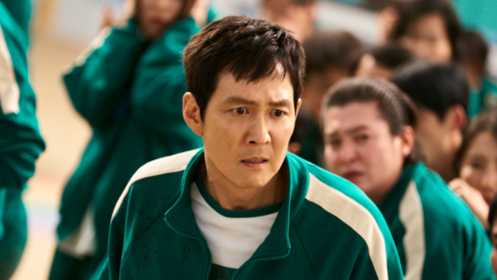 Lee Jung-jae looks distressed in a green Squid Game tracksuit