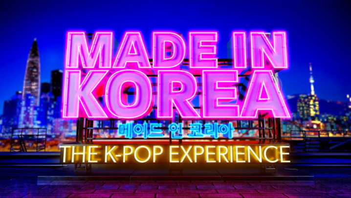 The words "Made In Korea" are written in a graphic of a pink neon sign, above "The K-Pop Experience" in yellow neon. Between the two, there is Korean writing in blue neon signage