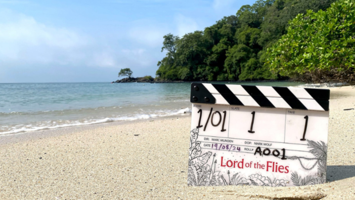 A clapperboard for Lord of the Flies, stood upright in the sand on a tropical beach