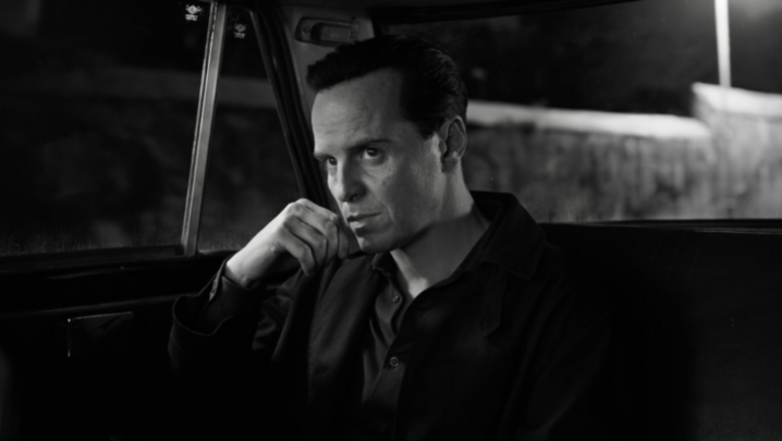 In a black and white image, Andrew Scott, playing Tom Ripley, looks ahead in a taxi