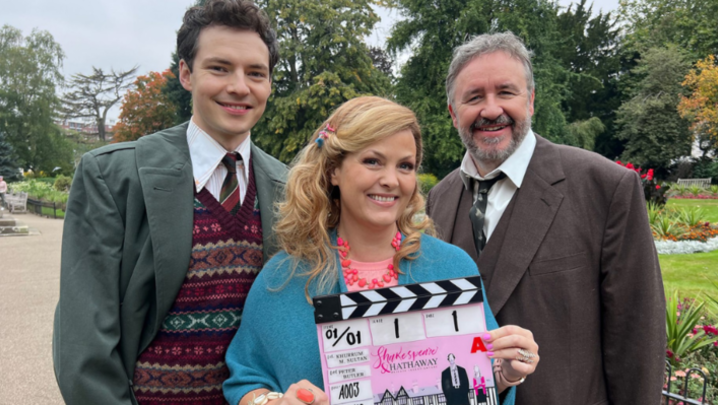 Patrick Walshe McBride, Jo Joyner and Mark Benton stand outdoors, smiling, with Joyner holding a clapperboard