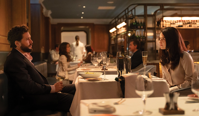 Kit Harington and Marisa Abela as Sir Henry Muck and Yasmin in Industry S3 talk over dinner in a high-end restaurant