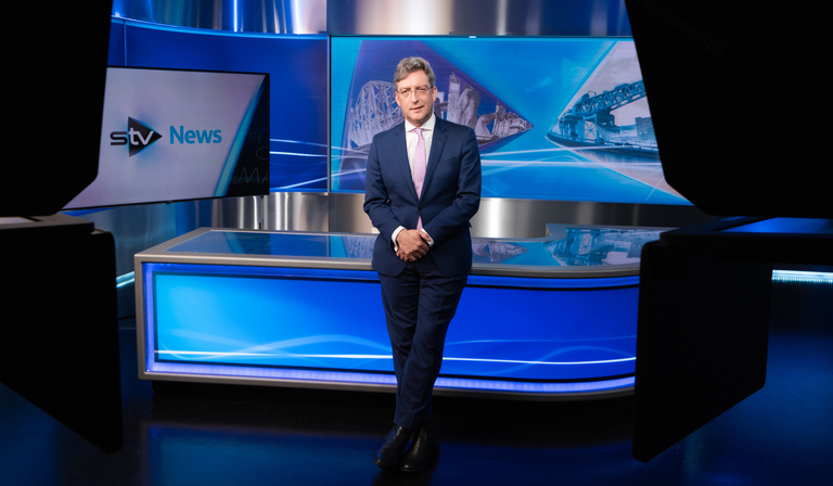 Colin Mackay stands in an STV news studio