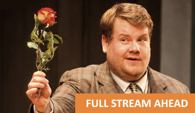 James Cordon on stage holding a rose
