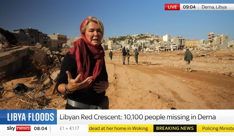 A news presenter is giving a piece to camera. Part of the chyron reads 'Libyan Red Crescent: 10,100 people missing in Derna'