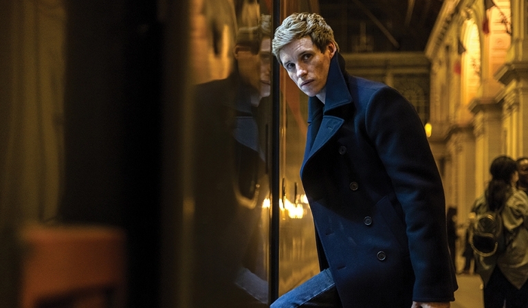 Eddie Redmayne steps onto a train as the titular assassin of The Day of the Jackal